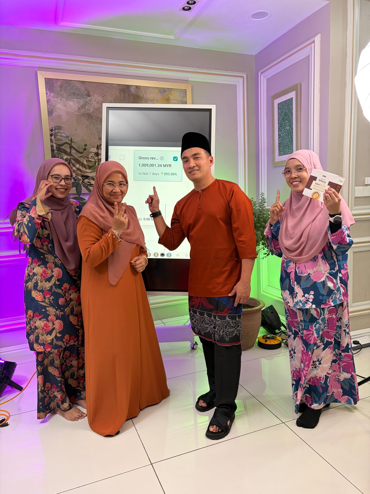 Najib berbaju Melayu merah bergambar bersama tiga wanita dalam sebuah majlis