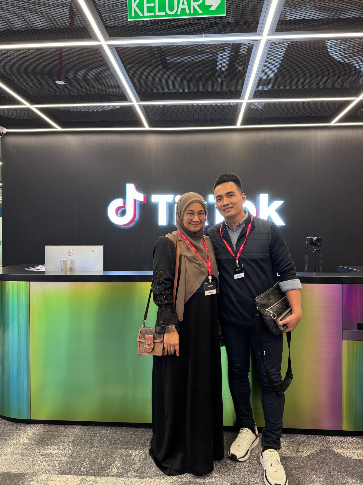 Najib dan seorang wanita bergambar di hadapan logo TikTok